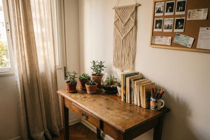 Coin bureau personnalisé dans une chambre d'adolescente avec objets décoratifs uniques, plantes succulentes et photos polaroid épinglées au mur